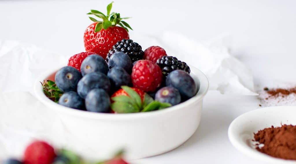 Frische Beeren in einer weißen Schale mit Erdbeeren, Heidelbeeren und Himbeeren