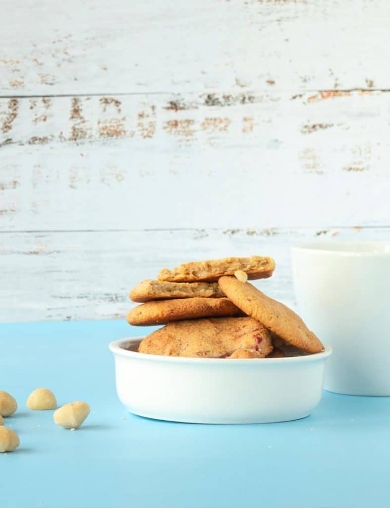 Mandelmehl-Macadamia-Kekse in einer weißen Schale mit einer weißen Tasse im Hintergrund. 