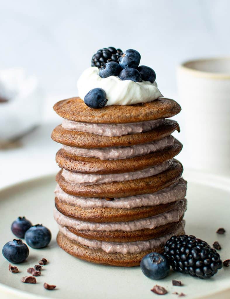Stapel aus Mandelmehl-Pancakes mit Creme und Blaubeeren auf einem Teller