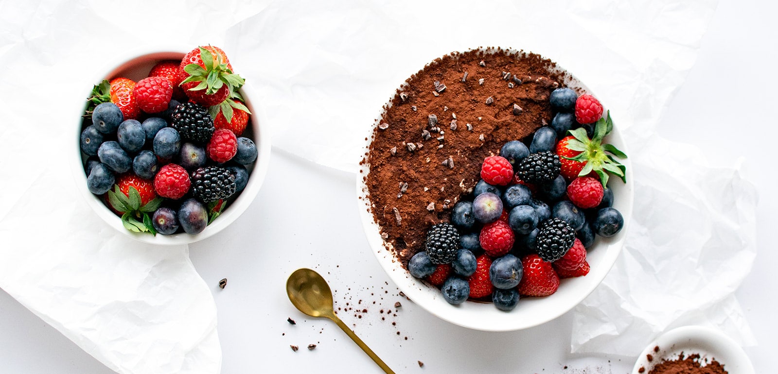 Low Carb Tiramisu Bowl mit Beeren und separate Schale frischer Beeren aus der Vogelperspektive.