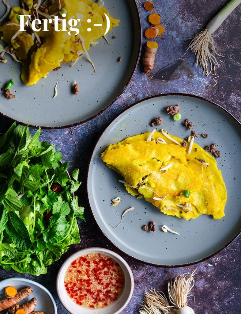 Das fertige Banh Chhaev aus der  Vogelperspektive fotografiert auf 2 Tellern mit Sauce und Kräutern. 