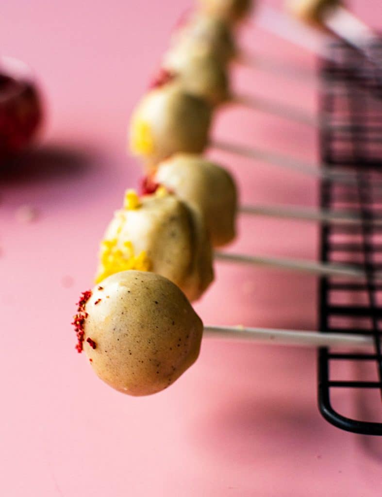 Fertige Lemon Cheese-Cake Pops, die auf einem Gitter trocknen.