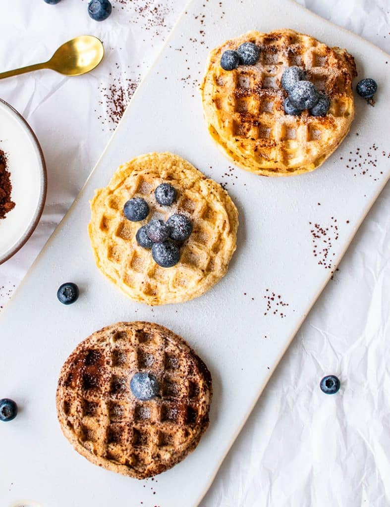 Drei Mandelmehl-Waffeln aus der Vogelperspektive: Mit Schokolade, mit Apfel und mit Beeren. 