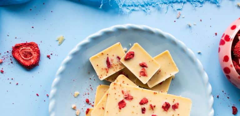 Selbstgemachte weiße Schokolade, Aufnahme von oben mit gefriergetrockneten Erdbeeren. .