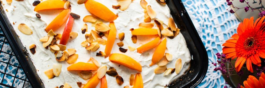Haselnusskuchen mit Aprikosen und Creme aus de Vogelperspektive fotografiert. 