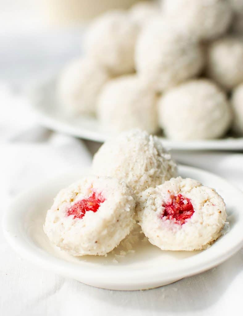 Angeschnittene Kokospraline mit cremiger Skyr-Kokos-Masse und frischer Himbeere im Inneren.