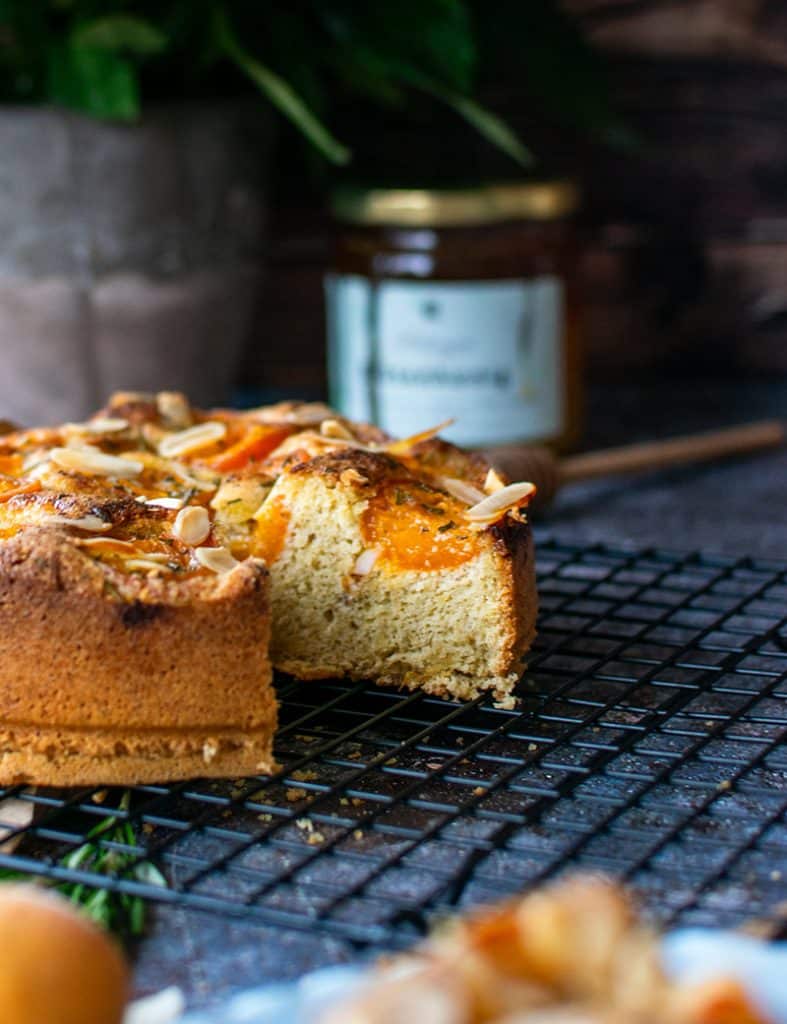 Angeschnittener Mandelmehlkuchen mit frischen Aprikosen.