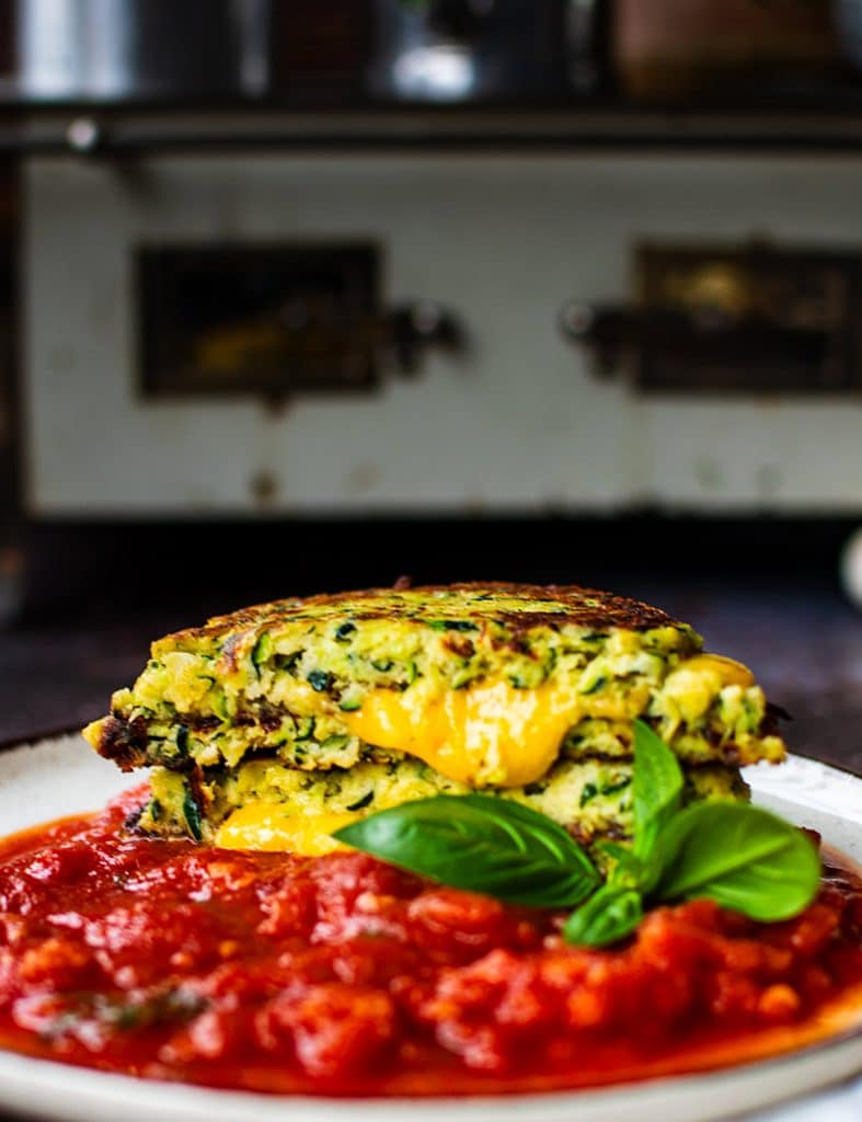 Käse läuft aus frisch gebratenen Zucchini-Puffern mit Mandelmehl.